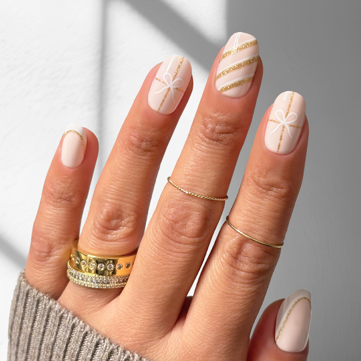 Oval Nude Press-On Nails with Gold Striping & White Motifs Oval Nude Press-On Nails with Gold Striping & White Motifs