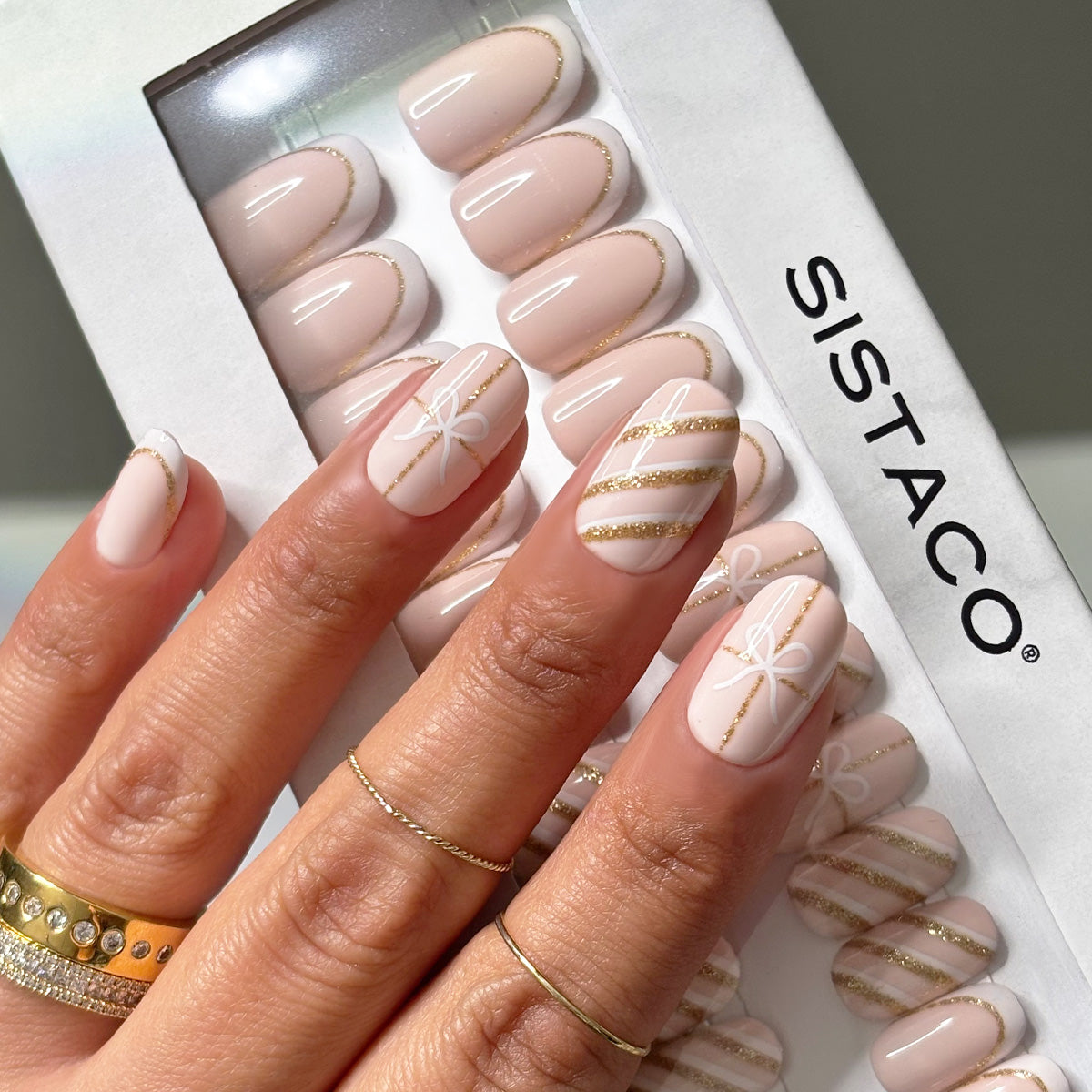 Oval Nude Press-On Nails with Gold Striping & White Motifs Oval Nude Press-On Nails with Gold Striping & White Motifs